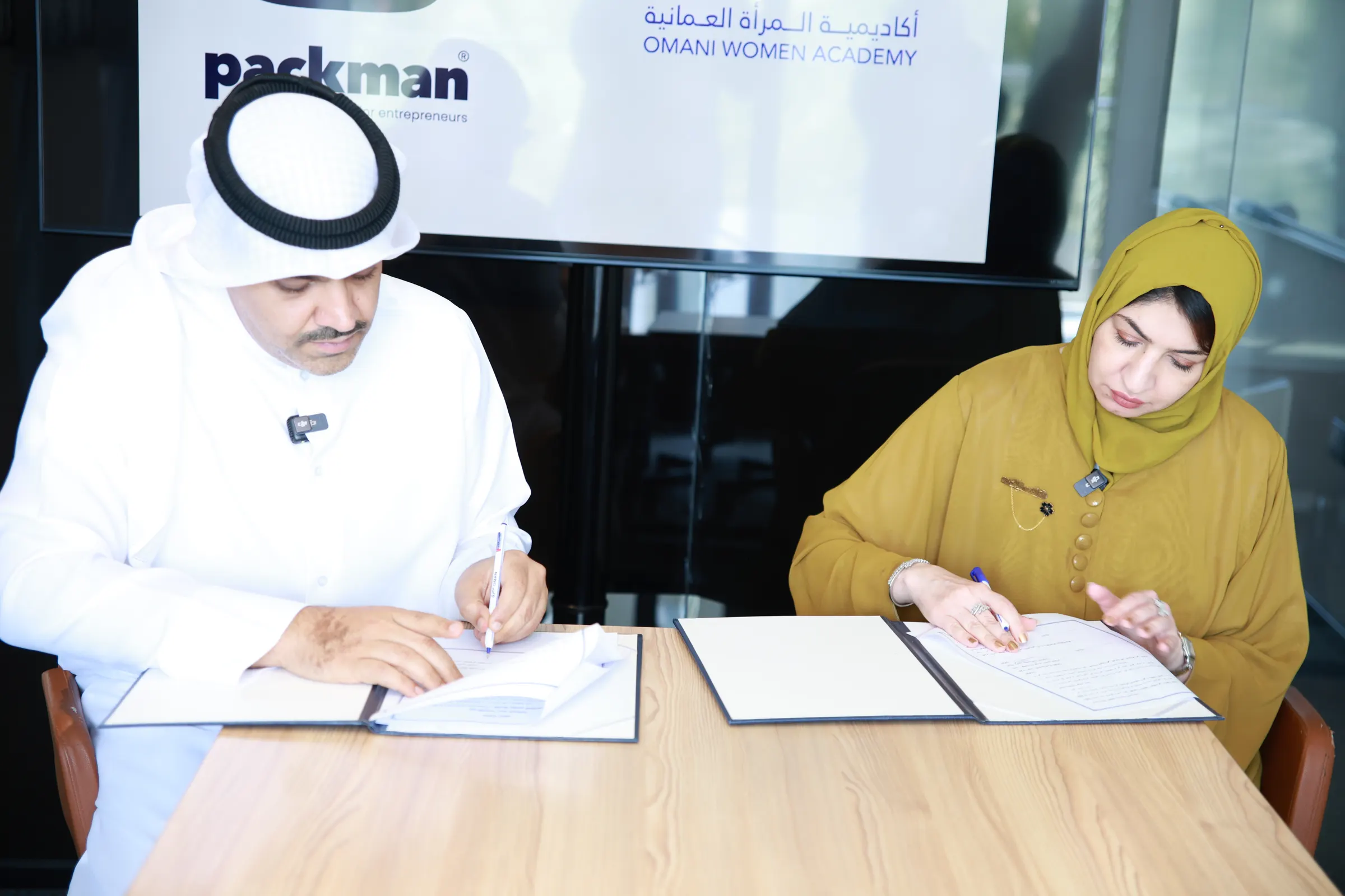 توقيع اتفاقية الشراكة على طاولة خشبية